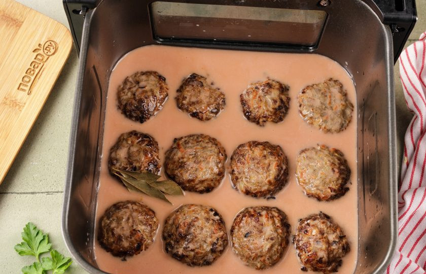 1. Этап. Ленивые голубцы в аэрогриле: Сложите голубцы в чашу аэрогриля и полейте их соусом, он должен покрывать их чуть больше, чем на половину. Если жидкости недостаточно, можно добавить ещё немного воды и аккуратно перемешать. Голубцы должны лежать равномерно в один слой.