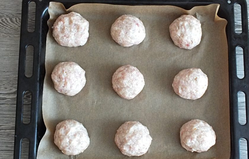 1. Этап. Мясные ватрушки с яйцом: Застелите противень пекарской бумагой. Фарш поделите на 9 частей. Скатайте шарики, выложите на противень.