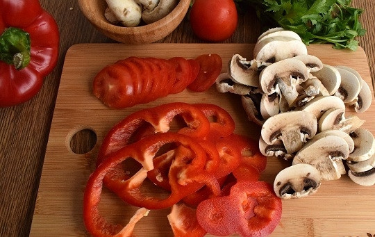 1. Этап. Диетическая куриная пицца без теста: Перец нарежьте тонкими брусочками, помидор — ломтиками, грибы — пластинками. Сыр натрите на мелкой терке.