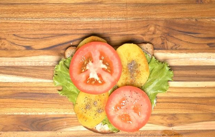 1. Этап. Бутерброды на шпажках: 8. Выложите на один ломтик хлеба салатный лист, затем выложите кружочки помидора, картофель.