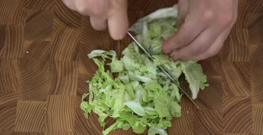 1. Этап. Хрустящий салат с мивиной: 1. Листья пекинской капусты очистите от белого центра, промойте и просушите. Нарежьте небольшими кусочками. Затем измельчите зеленый лук и добавьте к нарезанной капусте.