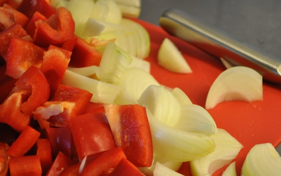 1. Этап. Гуляш из говядины в мультиварке: 2. Лук чистим, перец очищаем от зерен. Овощи нарезаем кубиками. Добавляем к мясу. Все вместе обжариваем.