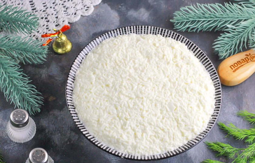 1. Этап. Крабовый салат на Новый год 2025: Сверху распределите ровным слоем натертые белки.