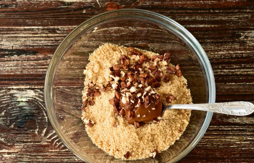 1. Этап. Конфеты из сгущенки: Всыпьте очищенные и немного измельченные грецкие орешки.