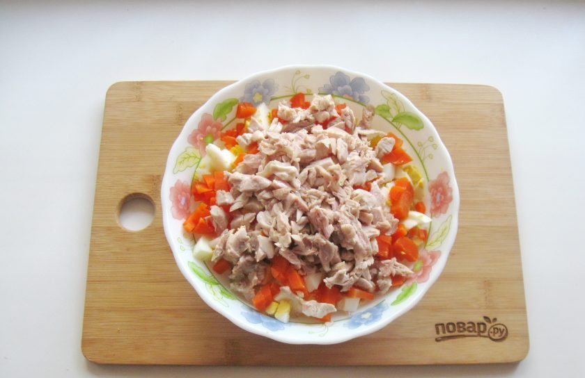 1. Этап. Оливье без горошка: Курицу отварите до готовности. Бульон вам пригодится. Отделите мясо от костей и шкурки, мелко нарежьте и добавьте в салат.