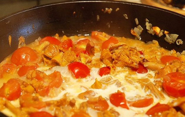 1. Этап. Паста с лисичками в сливочном соусе: Добавьте на сковороду помидоры черри, разрезанные пополам. Влейте сливки и добавьте специи по вкусу. Перемешайте и готовьте под крышкой на минимальном огне. Тушим 10 минут.