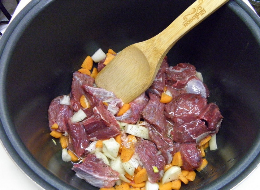 1. Этап. Тушеная говядина с черносливом: Включите мультиварку на самый мощный режим, у мня это функция разогрева пищи. Влейте растительное масло, добавьте мясо и овощи, соль, перец молотый. Перемешайте и закройте мультиварку, пусть мясо обжарится минут 10. Откройте перемешайте, дайте ему обжариться еще минут пять.