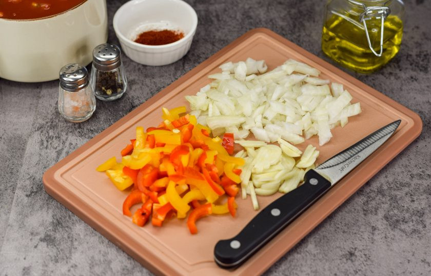 1. Этап. Шакшука: Очистите репчатый лук, чеснок и сладкий перец. Овощи ополосните и просушите. Нарежьте лук небольшими кубиками, чеснок также мелко нарубите, сладкий перец нарежьте полосками.