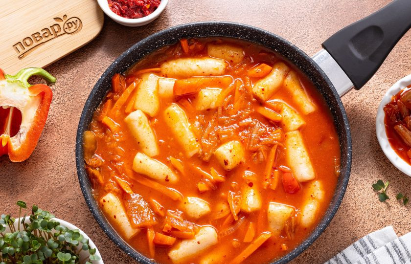 1. Этап. Токпокки с кимчи: Влейте горячую воду, перемешайте и тушите на умеренном огне, под крышкой 6-10 минут, пока соус не загустеет.