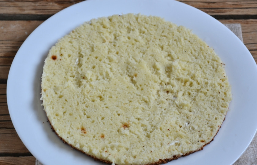 1. Этап. Торт Панчо с вишней: Острым ножом разрежьте остывший корж на 2 части. Нижнюю положите на плоское блюдо.