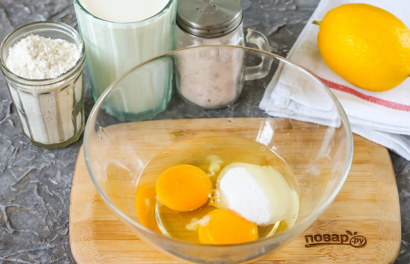 1. Этап. Лимонные блины: Вбейте куриные яйца в глубокую емкость, всыпьте сахар. Так как в тесто будет вводиться лимонный сок, то чуть увеличьте норму сахарного песка, чтобы блины не получились кислыми на вкус.