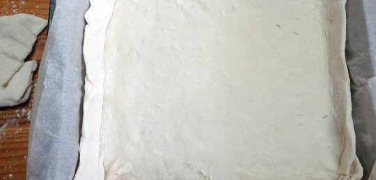 1. Этап. Пирог с грибами из слоеного бездрожжевого теста: 6. На противень, застеленный пергаментом, выложить половину теста, раскатанного по размеру.