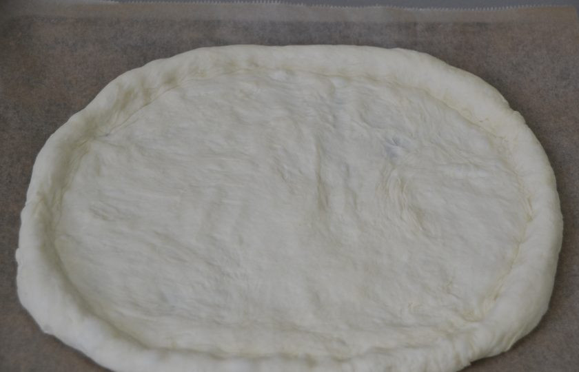 1. Этап. Пицца Пикантная: Раскатайте тесто в пласт, переложите его на лист для выпечки, сформируйте бортики.