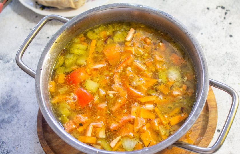 1. Этап. Куриный суп с солеными огурцами: Сладкий перец очистите от семян и нарежьте мелкими кусочками, отправьте в кастрюлю к овощам.