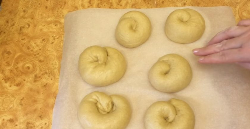 1. Этап. Булочки Улитки с заварным кремом: 8. Выложите булочки на выстеленный пергаментом противень на расстоянии друг от друга. Смажьте булочки взбитым с водой желтком и выпекайте в разогретой до 180-190 градусов духовке 20-25 минут.