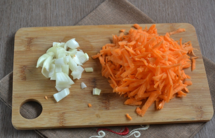 1. Этап. Запеченная скумбрия в фольге с морковкой: Луковицу порежьте мелкими кубиками. Слишком много лука не нужно, наш главный ингредиент – морковь, вот ее как раз следует взять побольше – 1 крупную или 2 небольших. Натрите морковку на крупной терке. Спассеруйте овощи в небольшом количестве растительного масла до мягкости.