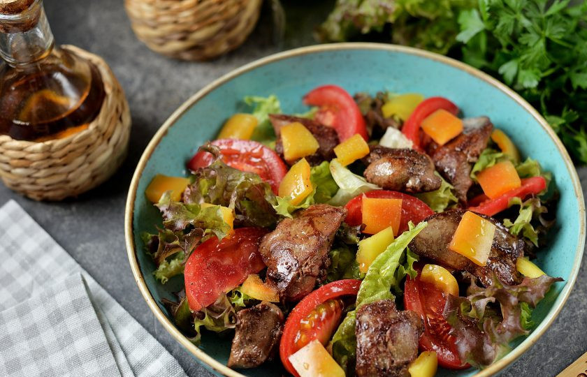 1. Этап. Салат с печенью, сладким перцем, помидорами и орехами: Выложите печень, посыпьте ее нарезанным болгарским перцем, посолите, поперчите, сбрызните оливковым маслом и бальзамическим уксусом.