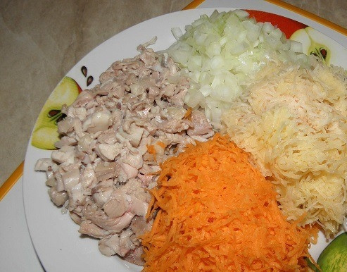 1. Этап. Картофельные котлеты с морковью: Окорочок положите в кастрюльку, залейте водой и отварите, предварительно немного подсолив воду. Затем остудите его и обберите с кости мясо, мелко его порубив. Натрите на терке очиненный лук, морковь и картофель. Все овощи для блюда должны быть свежими.