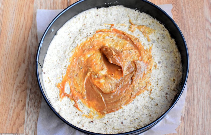 1. Этап. Песочный пирог с орехами: Выложите тесто в разъемную форму и разровняйте. Сверху намажьте тесто тонким слоем вареной сгущенкой.