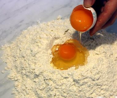 1. Этап. Домашнее тесто фило: 1. В большую миску высыпьте 6 стаканов муки (2 оставшихся стакана будут использованы при раскатывании теста). Сделайте дырку в центре и добавьте воды (начните с одного стакана), а также ракию или уксус. Перемешайте вилкой. Добавьте оливковое масло, продолжая перемешивать. При необходимости добавьте еще воды. Тесто должно быть мягким.