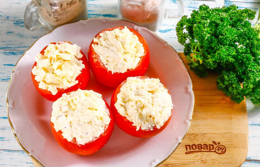 1. Этап. Помидоры с плавленным сыром и чесноком: Нафаршируйте начинкой очищенные от мякоти помидоры, выкладывая чуть выше края овощей.