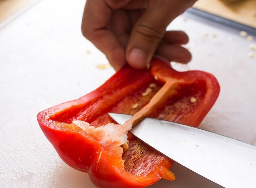 1. Этап. Пепероната по-сицилийски: 2. Перцы разрежьте пополам, удалите семена и перепонки, затем нарежьте их небольшими ломтиками.