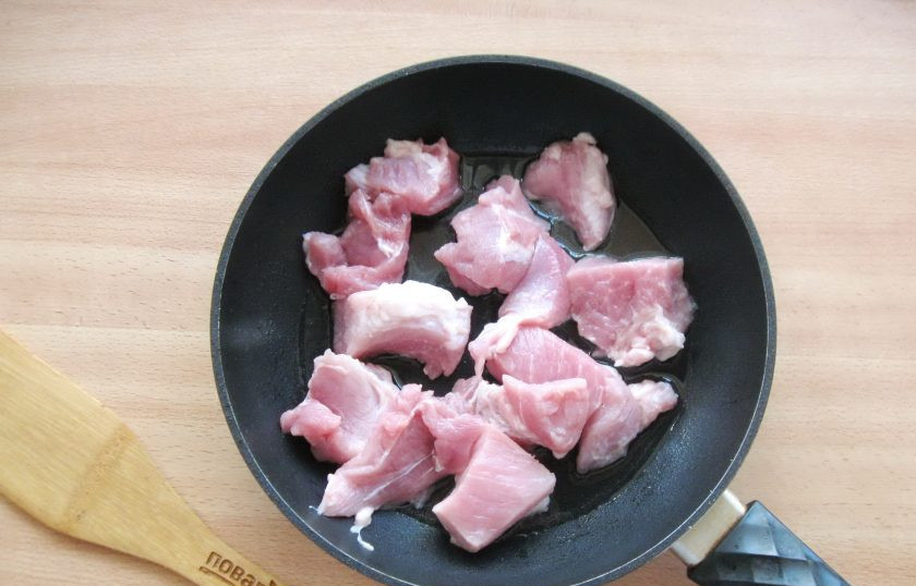 1. Этап. Макароны по-деревенски: Мякоть свинины порежьте небольшими кусочками и выложите в сковороду с подсолнечным маслом.