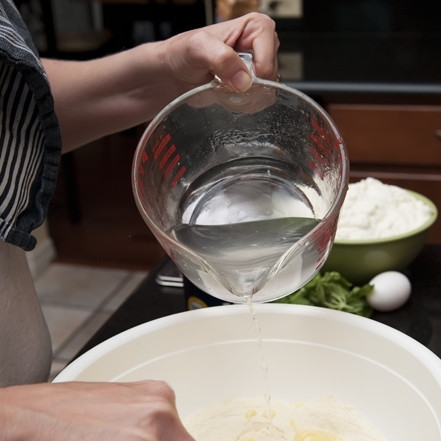 1. Этап. Равиоли с сыром: 4. Яичную смесь влейте в ямку, сделанную в муке, начните мешать. Постепенно добавляйте кипяченую воду.