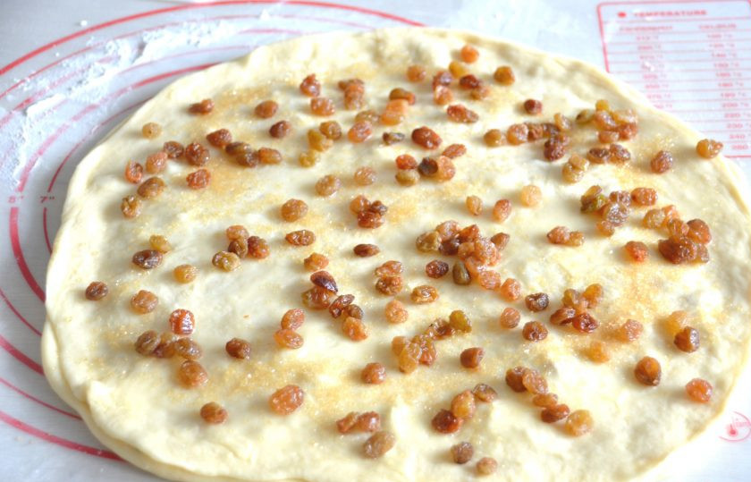 1. Этап. Канадские булочки: На первый пласт теста выложите второй пласт, который смажьте растопленным сливочным маслом, посыпьте коричневым сахаром и изюмом.