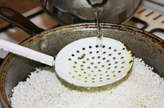 1. Этап. Плов с куриным филе: Когда время приготовления будет уже подходить к концу, мы сливаем с риса воду и промываем его еще раз. Из казана извлекаем острый перец и выкладываем в него рис, равномерно распределяем. Добавляем еще кипятка, жидкость должна подниматься над рисом на 2-3 см. Теперь пробуем на соль и при необходимости досаливаем.