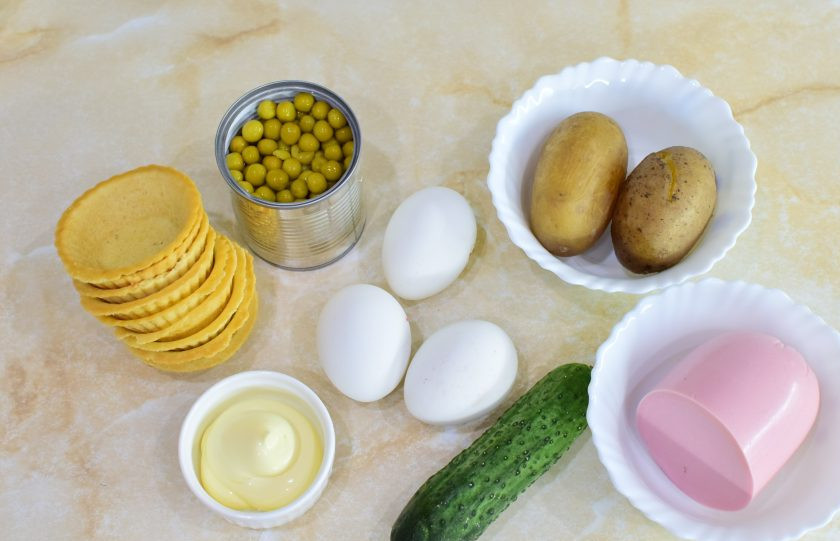 1. Этап. Тарталетки с салатом Оливье: Для приготовления салата подготовьте необходимые ингредиенты. Пропорции продуктов можно немного изменить на свой вкус. Заранее отварите яйца и картофель в мундире. Остудите.