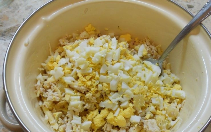 1. Этап. Салат с курицей и ананасами в тарталетках: 3. Вареные яйца очищаю и нарезаю кубиками, чеснок чищу и измельчаю с помощью мелкой терки, добавляю все ингредиенты к остальным продуктам.