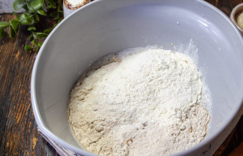 1. Этап. Цельнозерновые булочки для бургеров: Всыпьте пшеничную муку. Перемешайте ее с опарой ложкой.