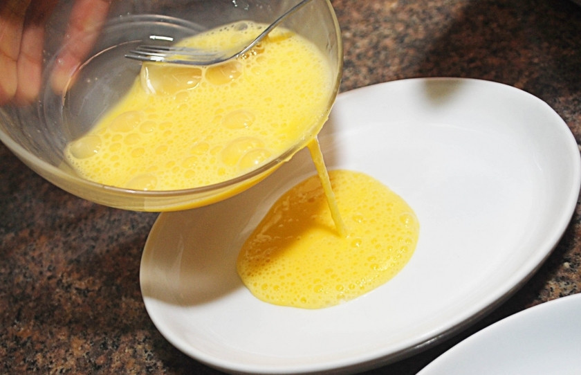 1. Этап. Хрустящие куриные палочки: Взбейте яйца. Перелейте их в плоскую тарелку. Так будет удобнее обмакивать кусочки куриного филе.