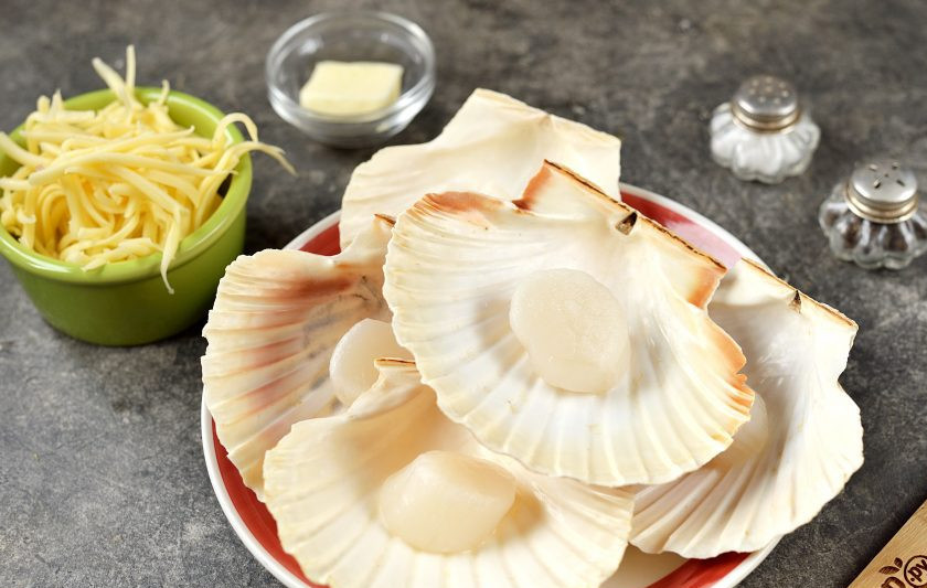 1. Этап. Гребешки в раковинах под сыром: Подготовьте все необходимые ингредиенты. Гребешки заранее разморозьте, слейте всю жидкость, промокните мясо бумажными полотенцами.