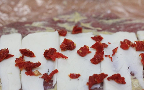 1. Этап. Праздничный рулет из свинины с начинкой: 2. Выложите половину полученной смеси на свинину, распределите кисточкой или ложкой равномерно. Сверху - слой сыра и прошутто.