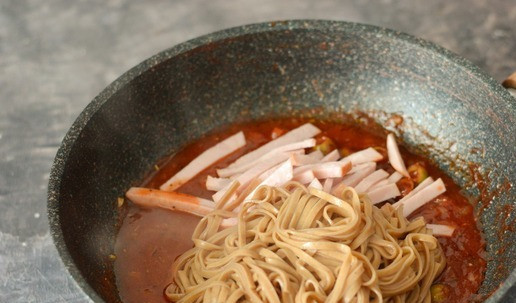 1. Этап. Гречневая лапша в пикантном томатном соусе: Следом за ветчиной добавьте в соус гречневую лапшу.