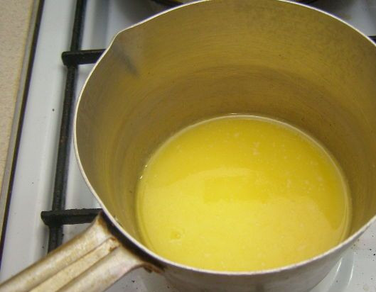 1. Этап. Творожно-черничный торт без выпечки: 2. Растапливаем сливочное масло, но не кипятим. Смешиваем масло с крошкой и выкладываем в форму, в которой будем делать пирог. Теперь нужно взбить сметану с сахаром.