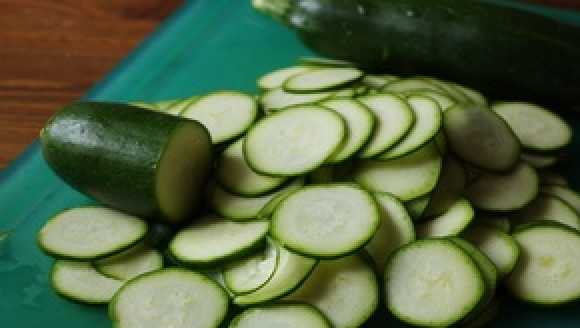 1. Этап. Запечённая семга с цуккини и луком: Цуккини вымойте под проточной водой. Очищать его не нужно. Отрежьте у овощей кончики с обеих сторон и нарежьте цуккини на кружочки толщиной в полсантиметра.