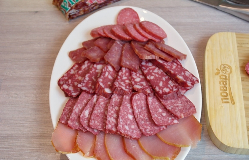 1. Этап. Мясная нарезка в виде ёлочки: Выкладываем все нарезанные колбасные изделия снизу вверх от более крупных кусочков к мелким.
