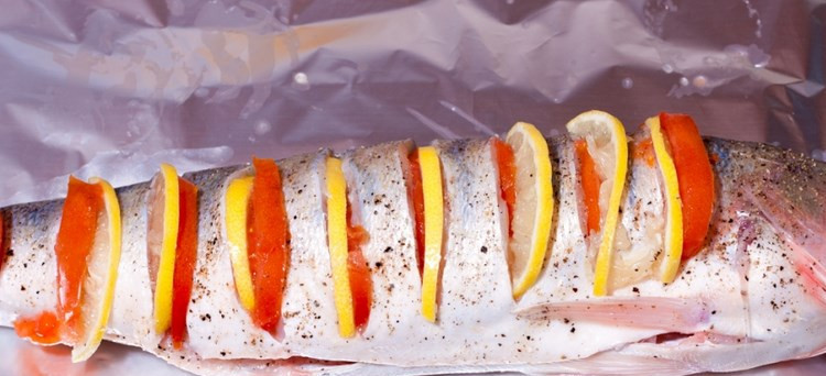 1. Этап. Судак под соусом в духовке: В разрезы вставьте лимонные дольки и помидорки.