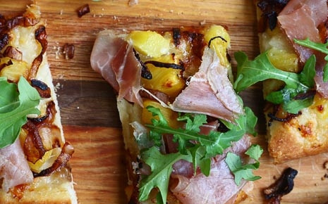 1. Этап. Пицца с ананасами: 6. Достаньте корж из духовки, выложите сверху лук, прошутто и рукколу. Вот и все, пицца с ананасами в домашних условиях готова. Можно нарезать её порционными кусочками и подавать к столу.