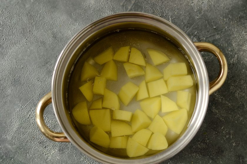 1. Этап. Борщ из савойской капусты: Налейте в кастрюлю воду, добавьте очищенный и порезанный кубиками картофель. Подсолите, доведите до кипения и варите 10 минут.