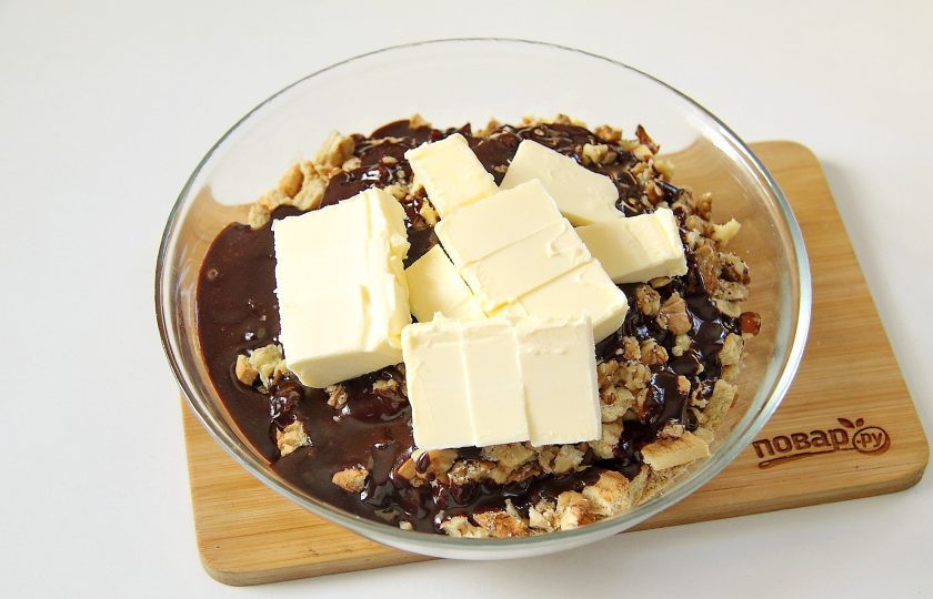 1. Этап. Кондитерская колбаска из печенья: 8. Добавьте нарезанное кубиками мягкое сливочное масло.