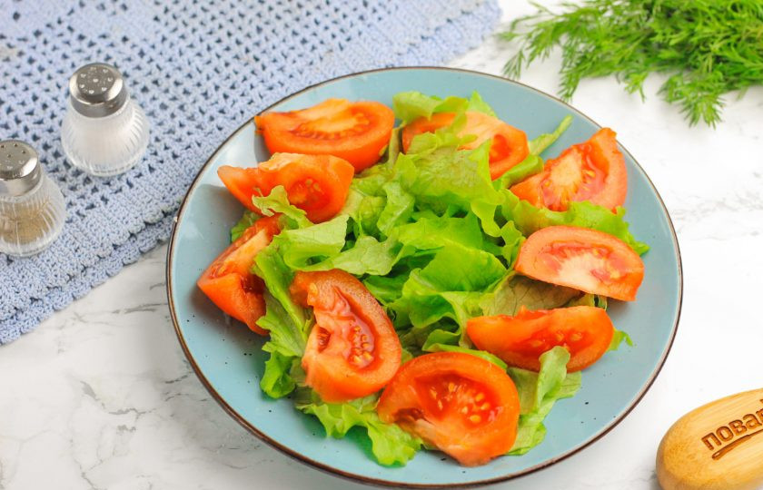 1. Этап. Салат из масляной рыбы холодного копчения: Нарежьте помидор крупными ломтиками и выложите на листовой салат.