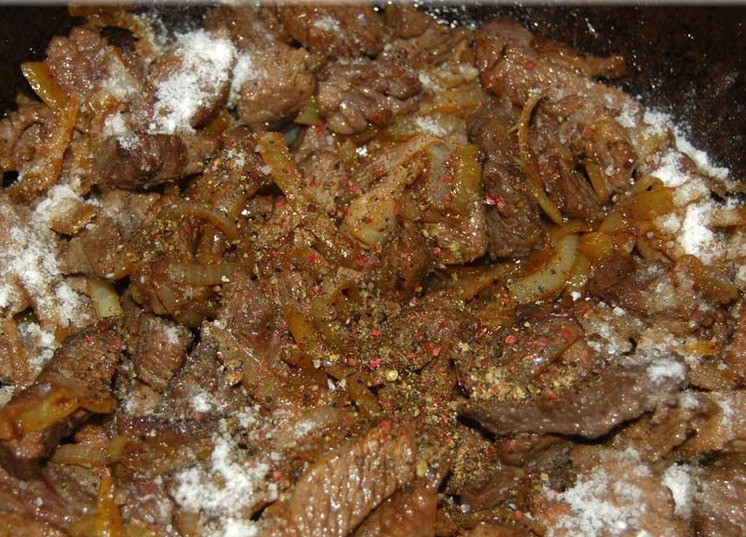 1. Этап. Мясо по-татарски: 8. Мясо добавить к луку, посолить и поперчить по вкусу. Все хорошенько перемешать.