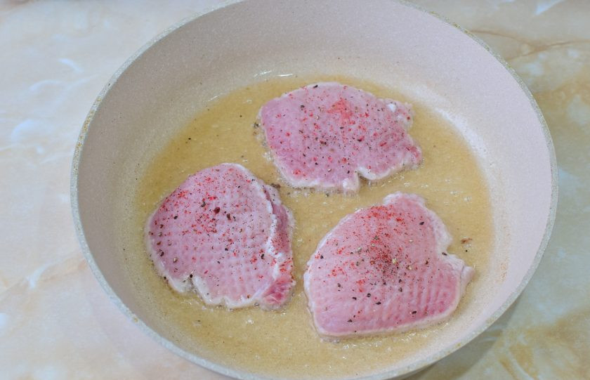 1. Этап. Свинина с кедровыми орешками: В горячую сковороду налейте растительное масло и обжарьте мясо с двух сторон. По вкусу посыпьте его солью и специями. Затем сделайте огонь меньше и доведите мясо до готовности. На это уйдет еще по 3-4 минуты с каждой стороны.