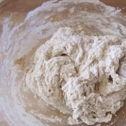 1. Этап. Пита: Добавляем жидкую смесь к сухой и ложкой перемешиваем тесто. Перемешивая, небольшими порциями подсыпаем в тесто оставшуюся муку.