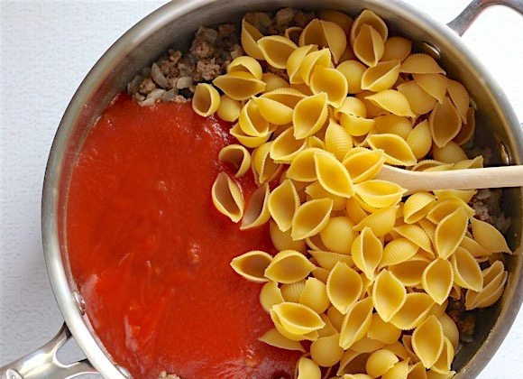 1. Этап. Ракушки с фаршем в томатном соусе: 3. Добавьте в сковороду томатный соус и сырые макароны.