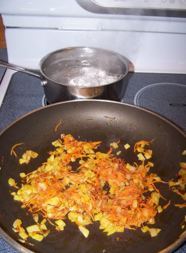 1. Этап. Суп со щавелем и курицей: Шаг 2. Пока мясо варится, нарежьте мелко лук и натрите на мелкой терке морковь. Лук с морковью переложите на разогретую с подсолнечным маслом сковороду. Жарьте на среднем огне до размягчения и румяности. Отварите яйца вкрутую (необходимо варить их около 7 минут).